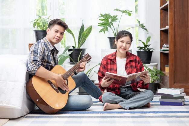 Hommes assis guitare et femmes tenant des livres et chantant.