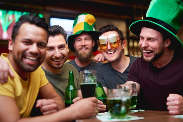 Hommes avec chapeau de lutin et bière célébrant la Saint Patrick