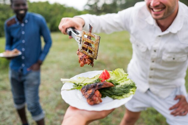 Hommes cuisine barbecue à l'extérieur