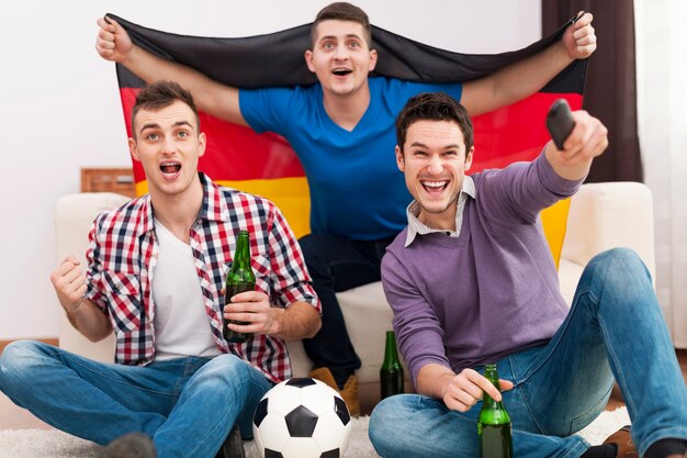 Hommes d'excitation acclamant le match de football