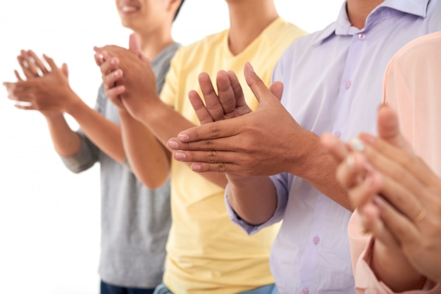 Hommes et femme méconnaissables debout dans la rangée et applaudissant