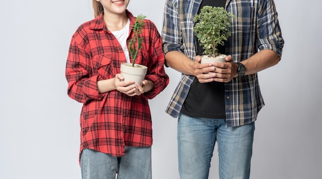 Hommes et femmes debout et tenant des pots de fleurs dans la maison