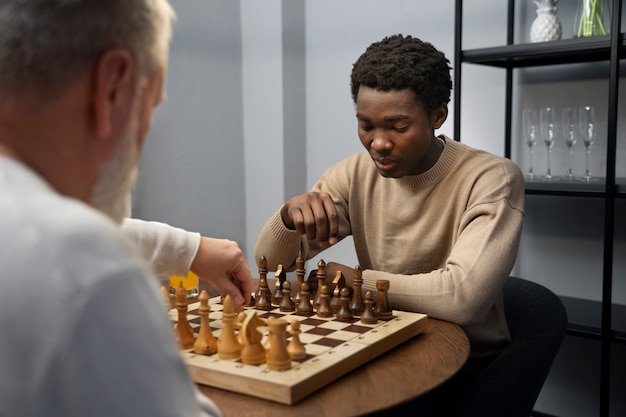 Hommes jouant aux échecs à l'intérieur vue latérale