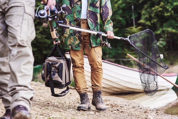 Hommes marchant et portant du matériel de pêche