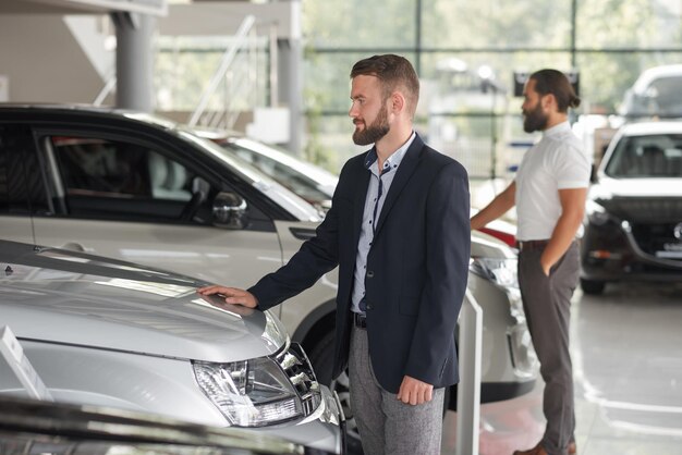 Hommes observant des automobiles dans la salle d'exposition