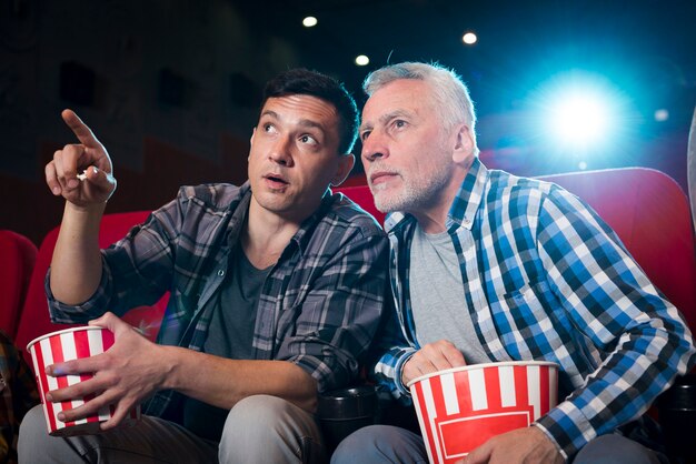 Hommes regardant un film au cinéma