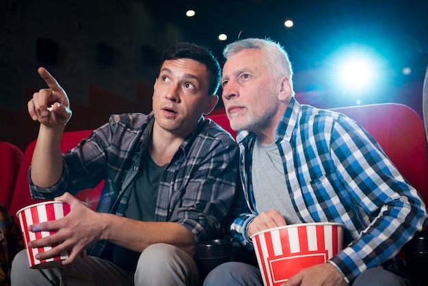 Hommes regardant un film au cinéma