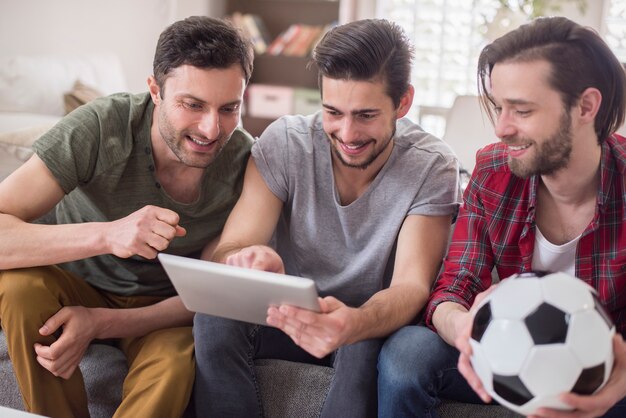 Hommes regardant la vidéo sur une tablette