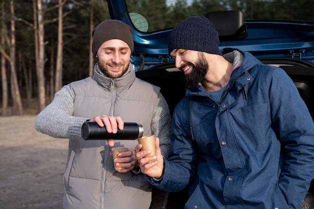 Hommes souriants de plan moyen avec des boissons