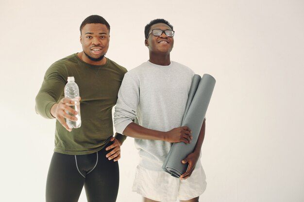 Hommes sportifs debout sur un mur blanc