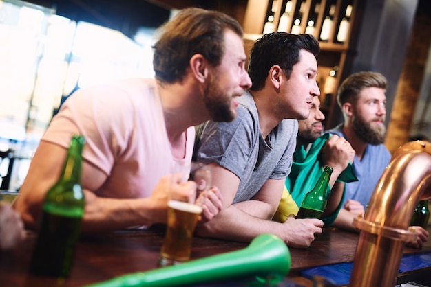 Hommes stressés regardant le match en concentration