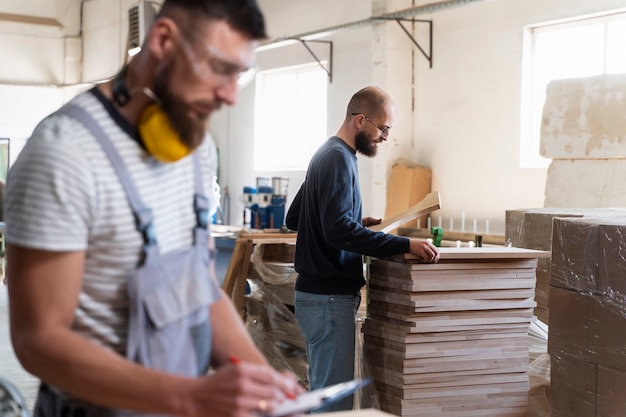 Photo gratuite hommes travaillant sur la découpe de panneaux mdf