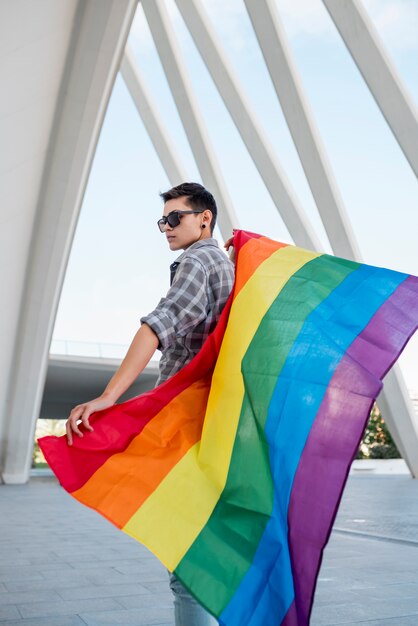 Homosexuel tenant le drapeau arc-en-ciel