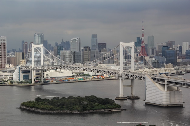 Horizon d'un gratte-ciel de la ville de Minato près d'un pont suspendu arc-en-ciel à Tokyo, Japon