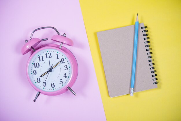 Horloge rose sur le fond coloré, Concept de l&#39;éducation