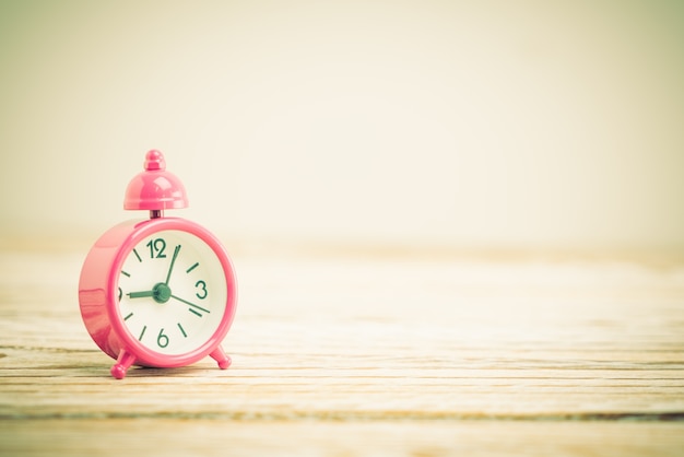 horloge rose sur la table en bois