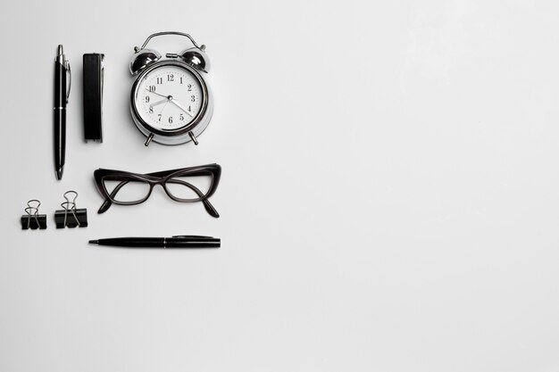 horloge, stylo et lunettes sur blanc