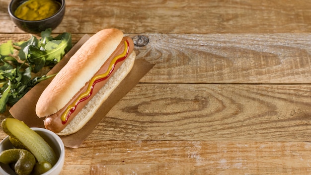 Photo gratuite hot-dog et légumes sur fond de bois