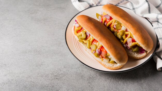 Hot-dogs à angle élevé sur plaque avec copie-espace