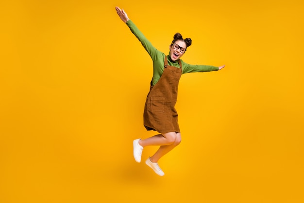 Hoto de fille joyeuse jump wear sur fond de couleur jaune
