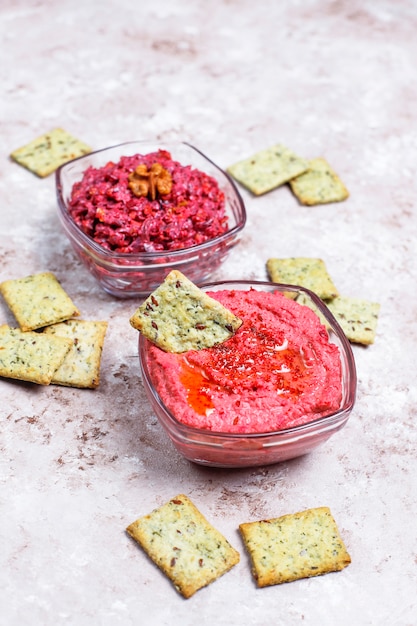 Photo gratuite houmous de betterave aux biscuits salés sur une surface claire