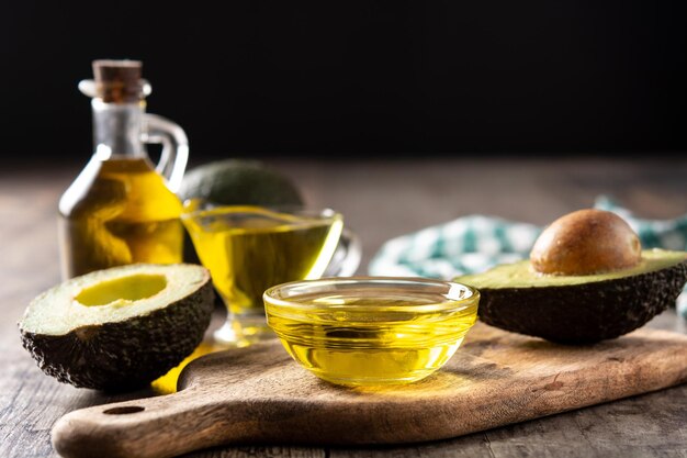 Huile et avocat frais mûr sur une table en bois rustique