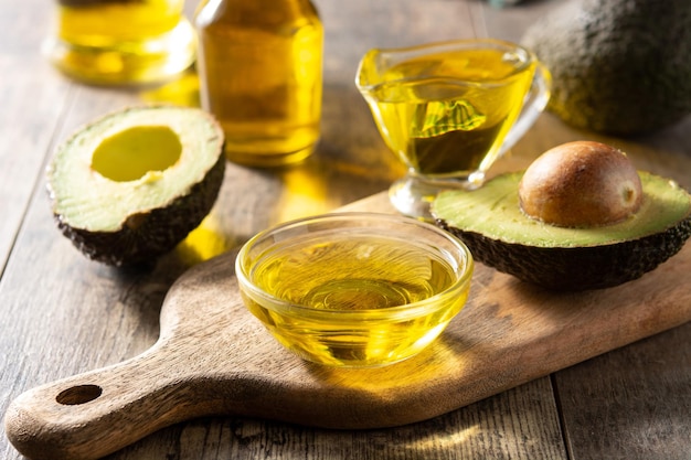 Huile et avocat frais mûr sur une table en bois rustique