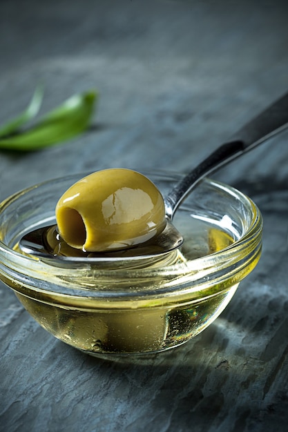 L'huile d'olive et la branche d'olivier sur la table en bois