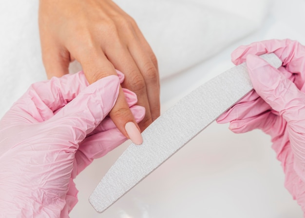 Hygiène et soins des ongles esthéticienne portant des gants close-up