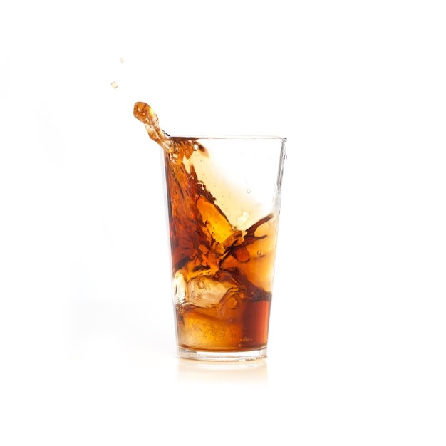 Ice tomber dans un verre avec une boisson brune