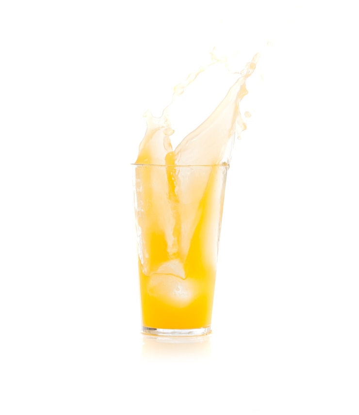 Photo gratuit ice tomber dans un verre avec une boisson jaune