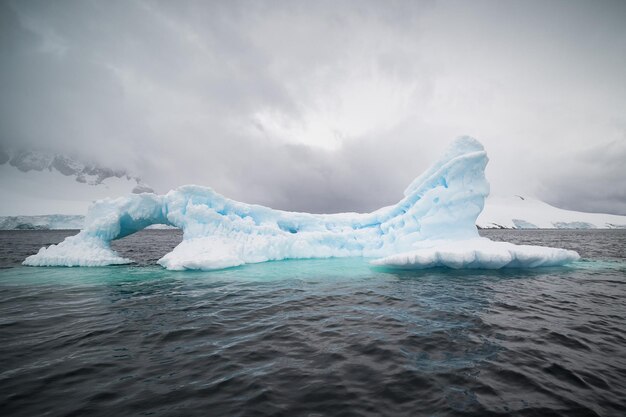 Iceberg dans la mer sous un ciel nuageux en Antarctique