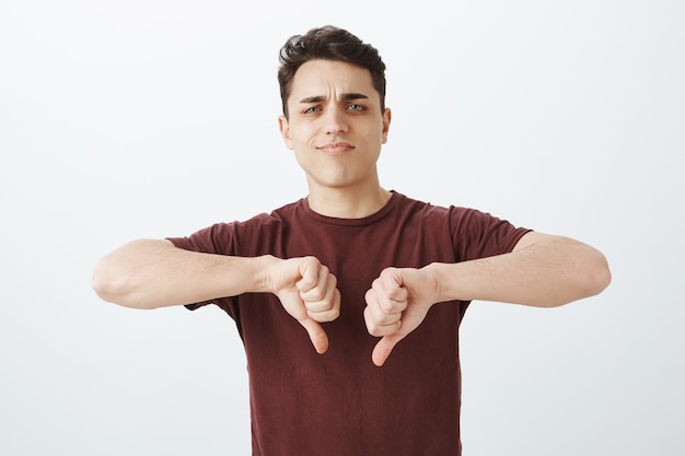 Photo gratuite l'idée est nul. jeune homme, à, pouces bas