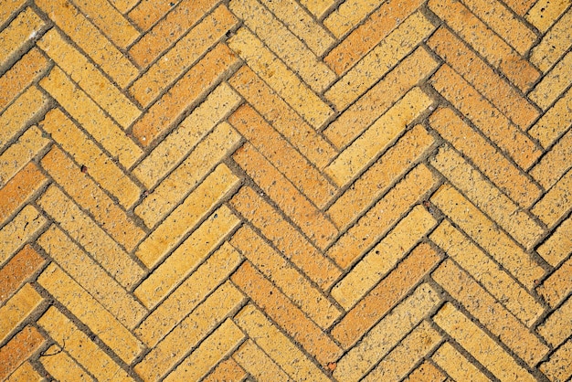 L'idée d'un fond d'écran simple pour votre bureau est un motif avec des carreaux rectangulaires en briques jaunes en forme de chevrons Texture diagonale abstrait de vieux pavés en céramique de briques