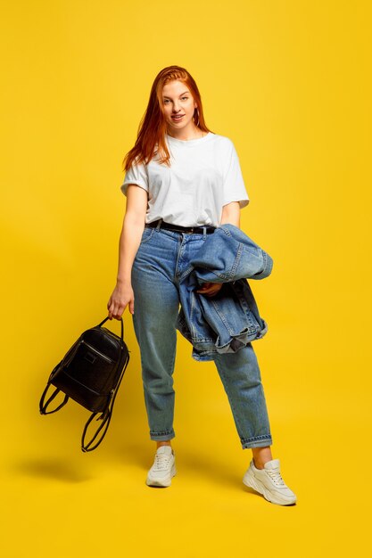 Il est plus facile d'être suiveur. Besoin d'un minimum de vêtements pour y aller. Portrait de femme caucasienne sur fond jaune. Beau modèle de cheveux roux féminin. Concept d'émotions humaines, expression faciale, ventes, publicité.