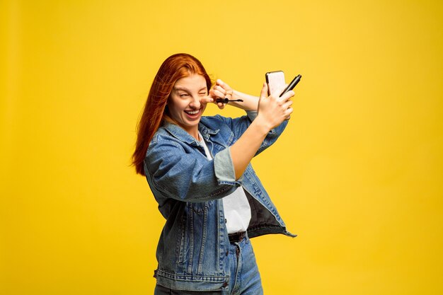 Il est plus facile d'être suiveur. Pas besoin de selfie pour se maquiller. Portrait de femme caucasienne sur fond jaune. Beau modèle de cheveux roux féminin. Concept d'émotions humaines, expression faciale, ventes, publicité.