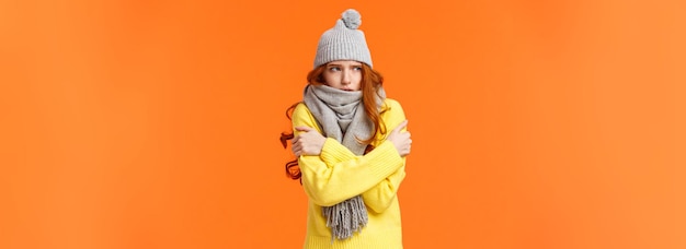 Photo gratuite il fait un froid glacial à l'extérieur d'une jolie rousse qui tremble et s'embrasse pour se réchauffer en attendant quelqu'un