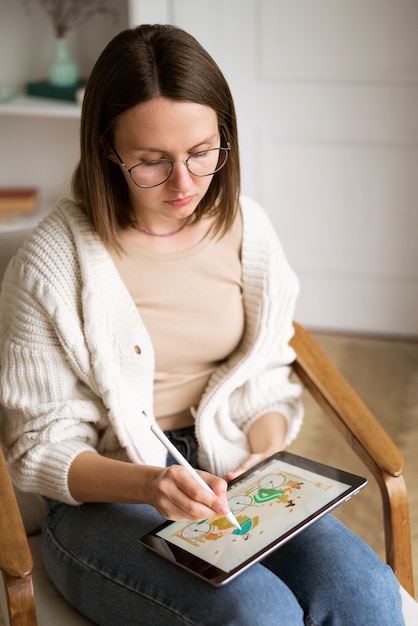 Photo gratuite illustratrice féminine adulte travaillant sur une tablette