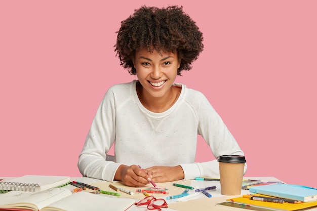 Illustratrice Féminine Positive Fait Des Croquis Avec Un Crayon Sur Une Feuille De Papier Vierge