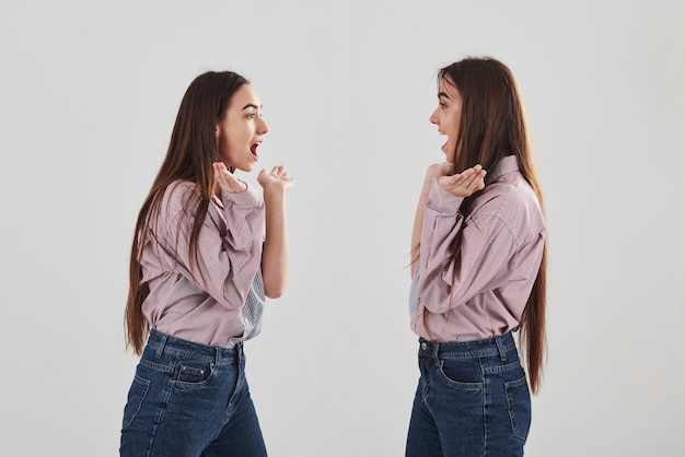 Ils Se Regardent Et ça Ressemble Presque à Un Miroir. Deux Soeurs Jumelles Debout Et Posant