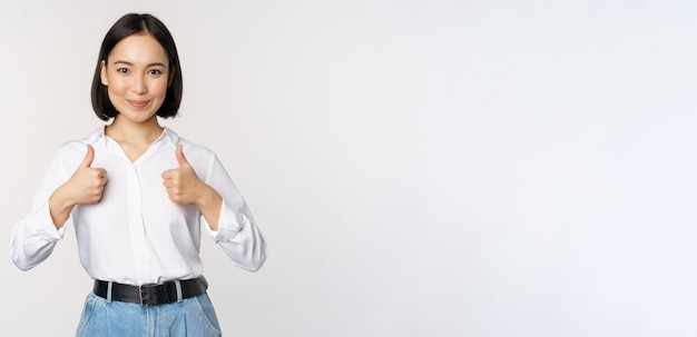 Image De La Belle Femme Asiatique Adulte Montrant Les Pouces Vers Le Haut Portant Des Vêtements Officiels De L'université De Bureau Rec