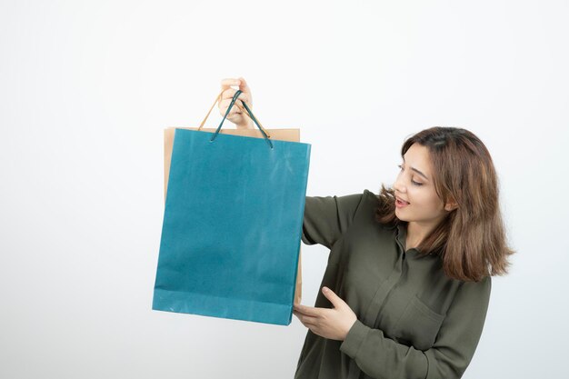 Image d'une belle fille aux cheveux courts avec des sacs à provisions debout. Photo de haute qualité