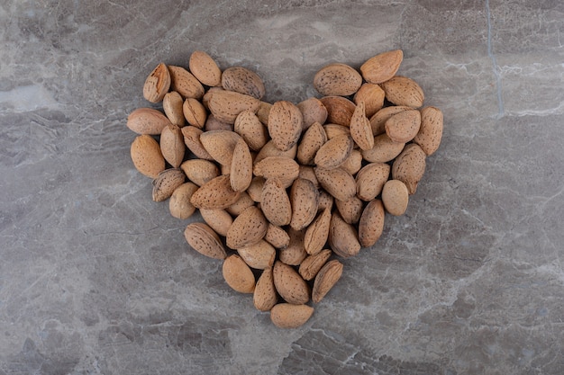 Une image d'un coeur fait d'amandes sur la surface de marbre