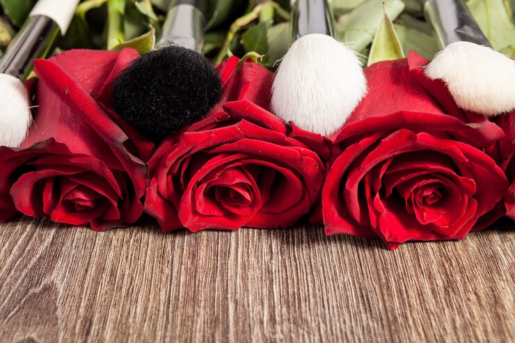 Photo gratuit image conceptuelle de pinceaux de maquillage à côté de roses sur fond de bois