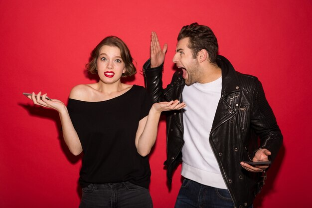 Image d'un couple punk avec des smartphones se querelle