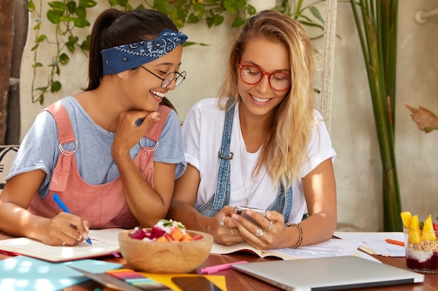 Image d'étudiants de race mixte heureux de communiquer pendant le processus d'apprentissage en ligne