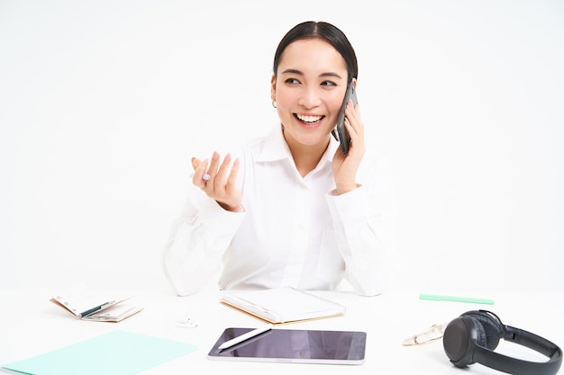 Photo gratuite image d'une femme asiatique d'employé de bureau dans des pourparlers de bureau sur un téléphone mobile discute du travail sur un téléphone portable whi