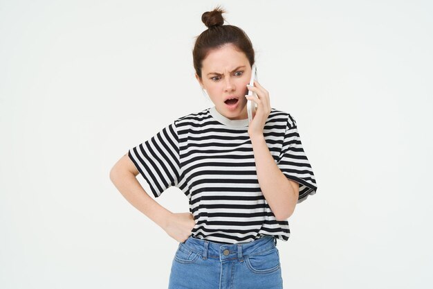 Photo gratuite image d'une femme brune qui se dispute en criant au téléphone en se dispute sur un téléphone portable debout