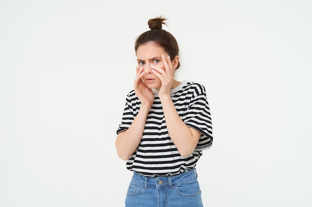 Photo gratuite image d'une femme effrayée par quelque chose de choquant debout sur un fond blanc