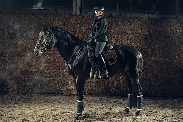 Image de femme heureuse assise sur un cheval de race pure